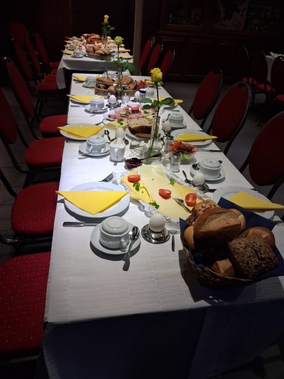 Gedeckte Tische mit Brötchen, Aufschnitt und allem was das Frühstücksherz begehrt